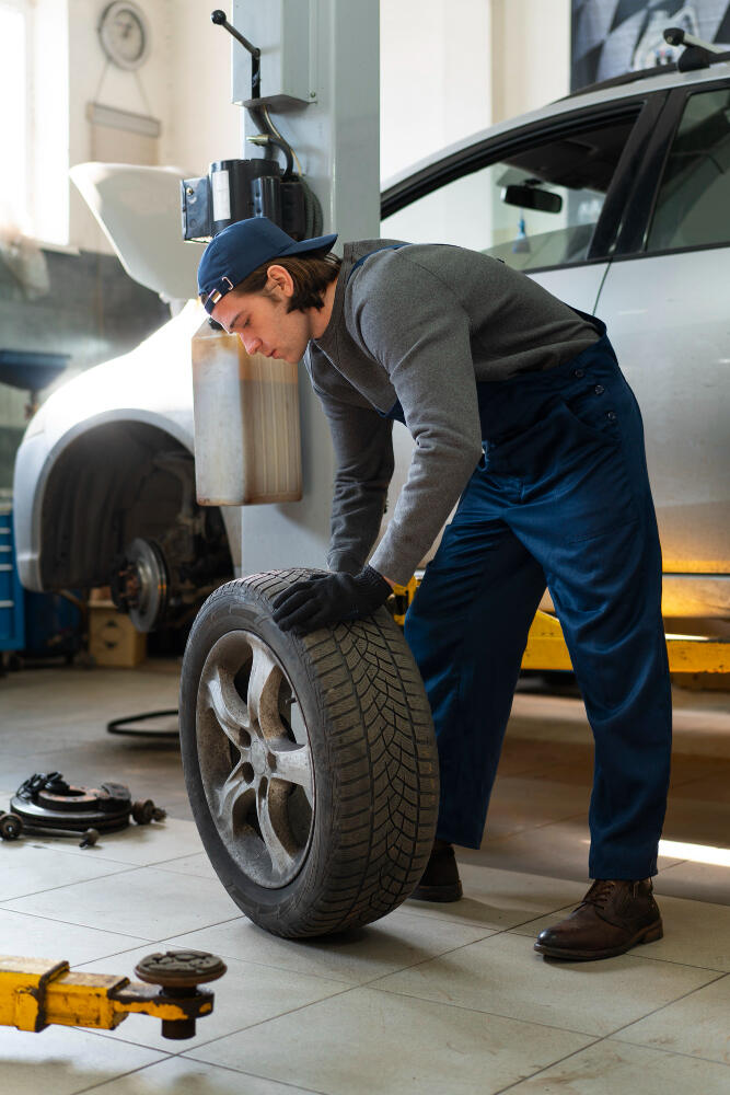 Skilled mechanic holding and working on a tire, showcasing expertise and dedication in the realm of car recovery