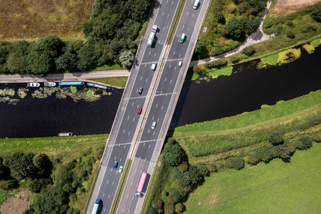 Aerial view of UK motorway bridge, depicting bustling traffic and potential car recovery situations