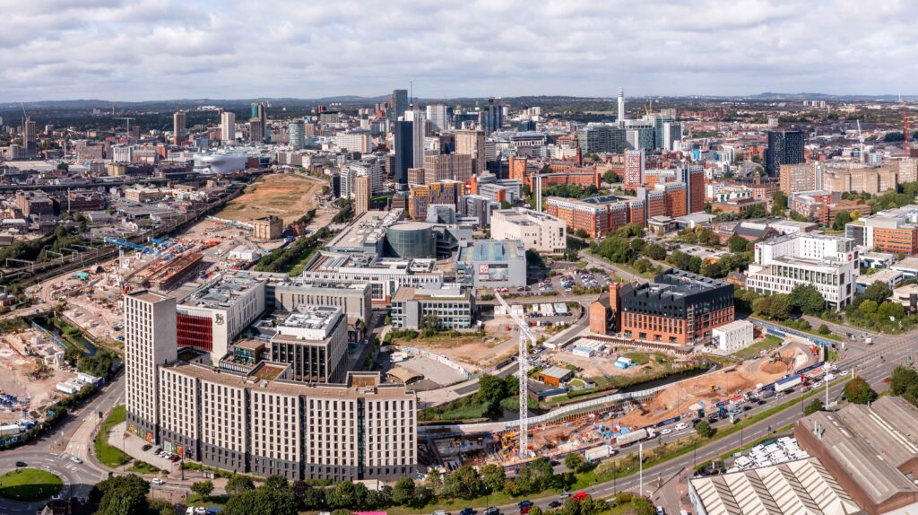 Birmingham cityscape aerial view, blending urban skyline with subtle elements suggesting potential car recovery scenarios below